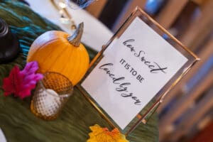 Pumpkin and framed quote with autumn leaves.