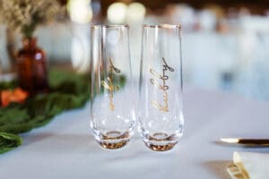 Two champagne glasses with gold lettering.