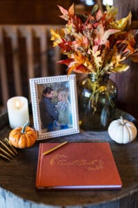 Guestbook with autumn decor and framed photo.