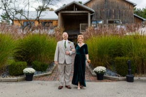 Couple posing in front of rustic building.