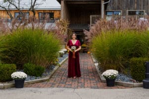 Woman in red dress holding bouquet outdoors.